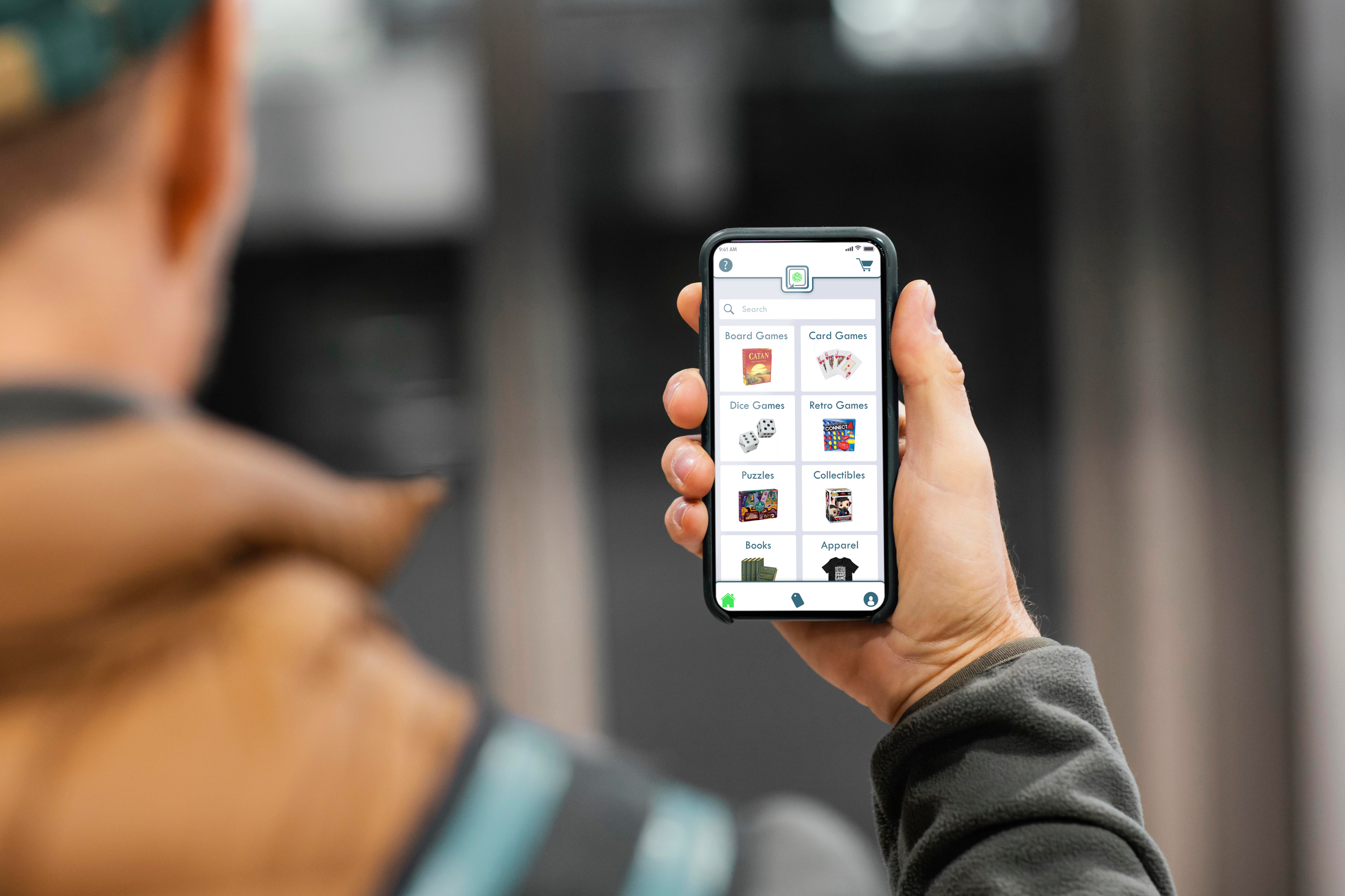 image of man holding phone looking at Games N Things screen