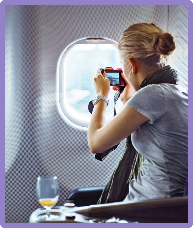 image of woman taking pictures out of airplane window
